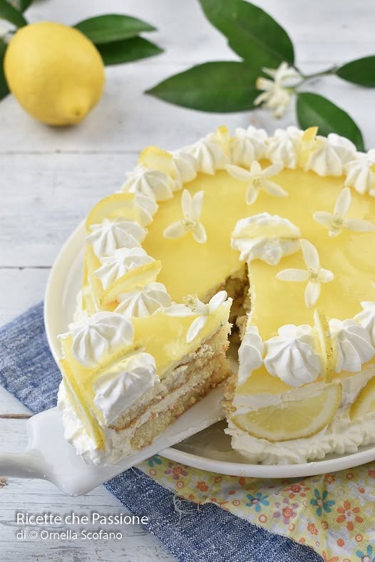 Torta chiara a strati con crema gialla al limone e ciuffi di panna
